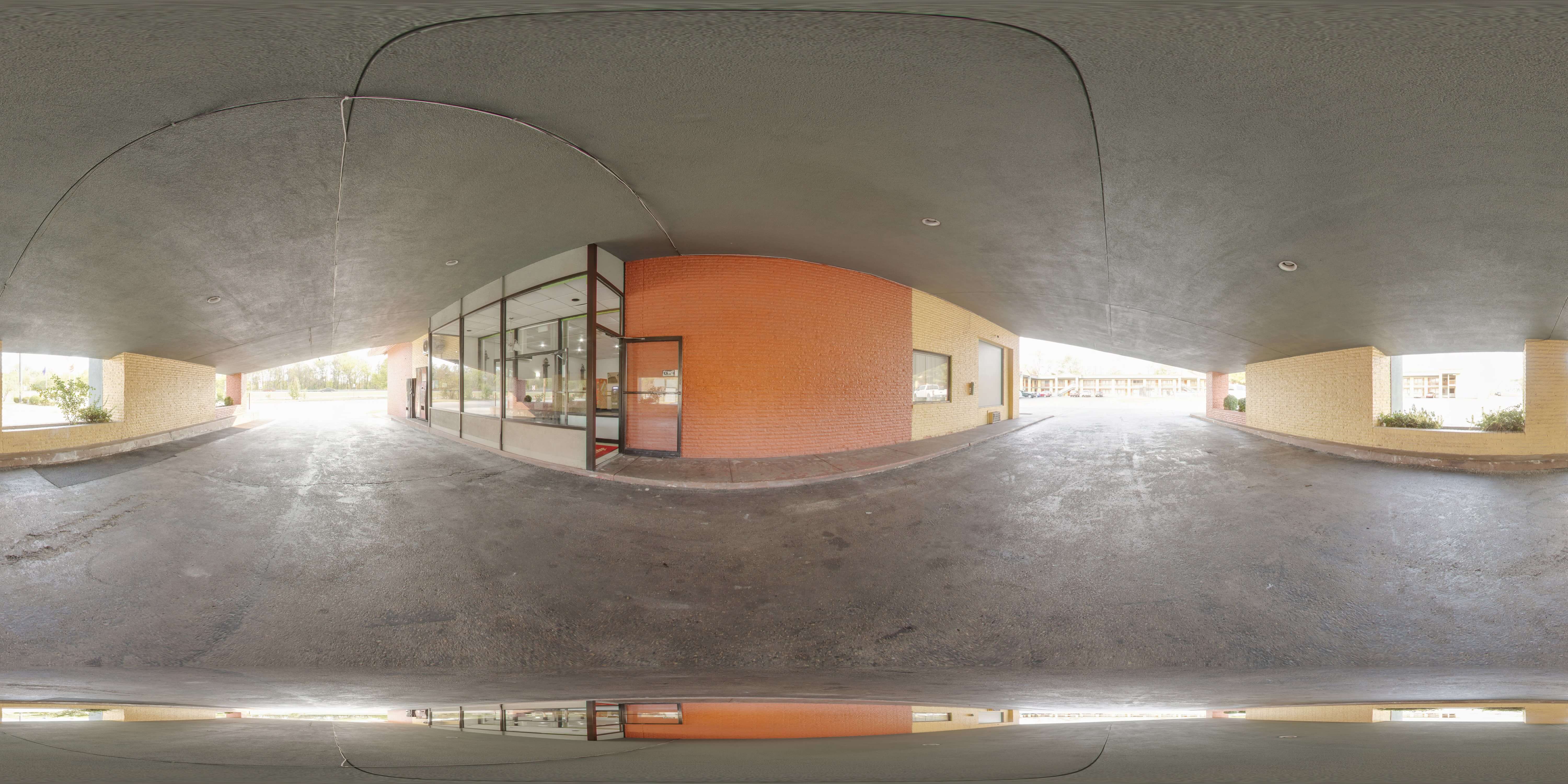 A 360-degree view of a parking lot with a building in the background