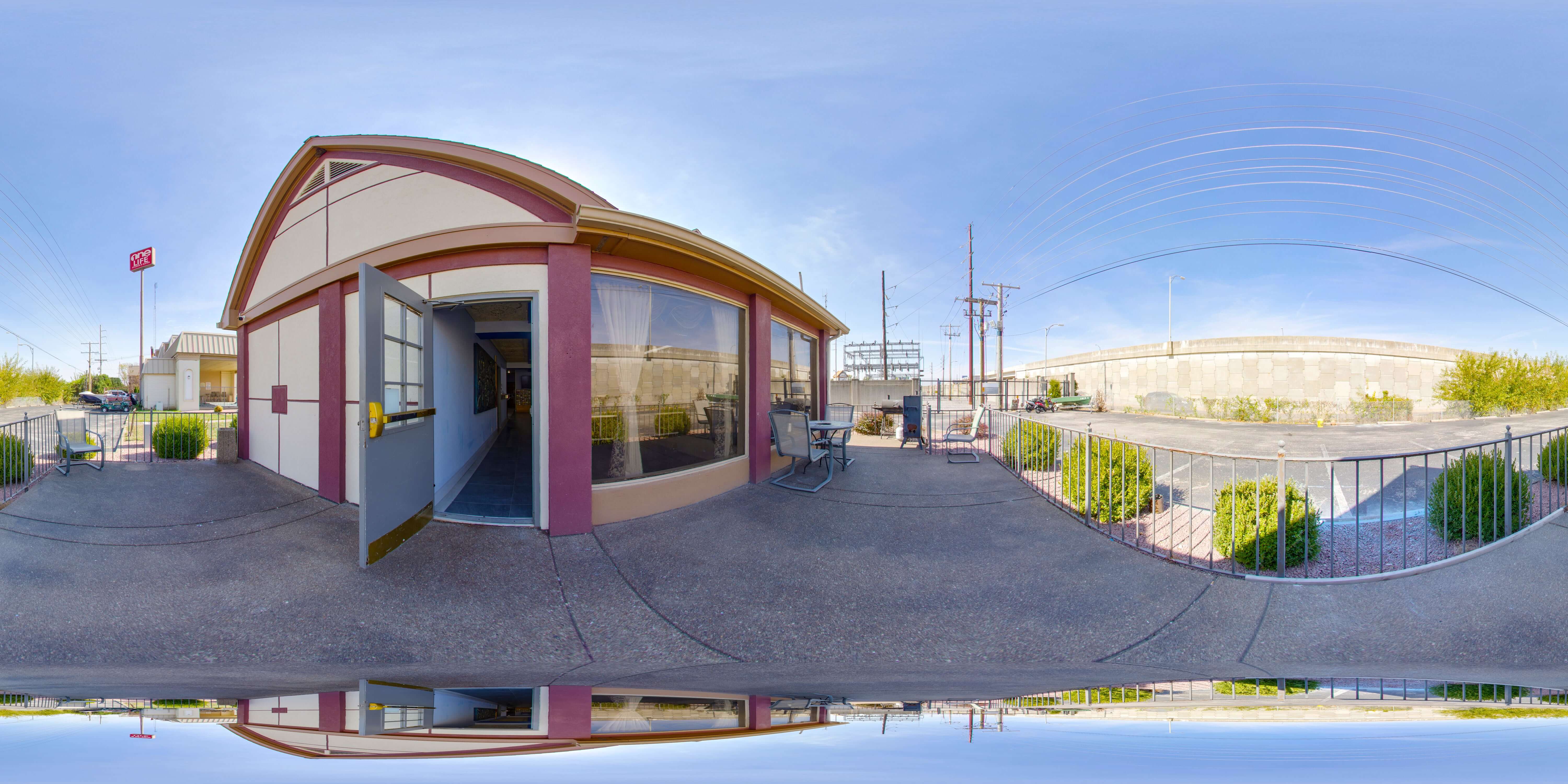 A 360-degree view of a hotel exterior with a curved roof and red and white color scheme.